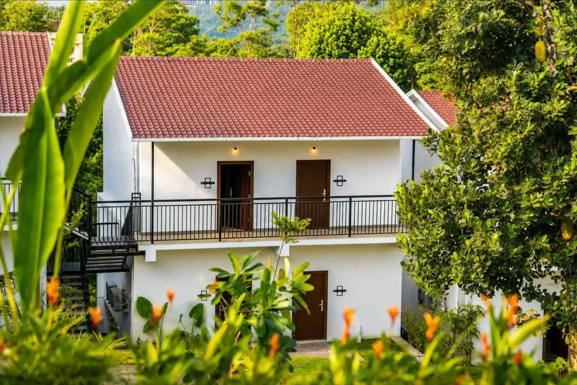 Vega Munnar cottage exterior with heliconia garden showing Vega Delight Cottage ground-floor entry