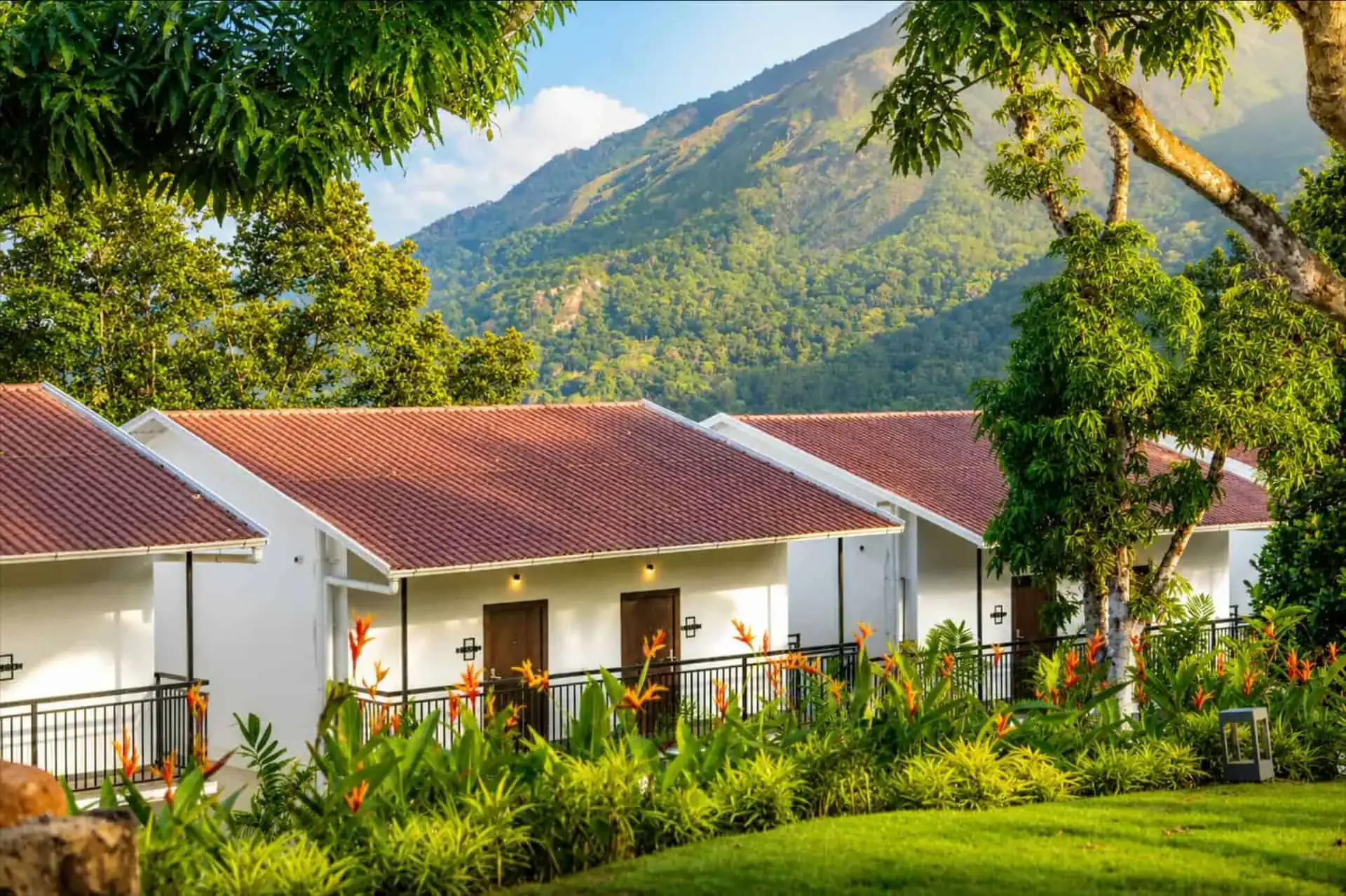 Cottage row with heliconia garden and dramatic mountain peak backdrop