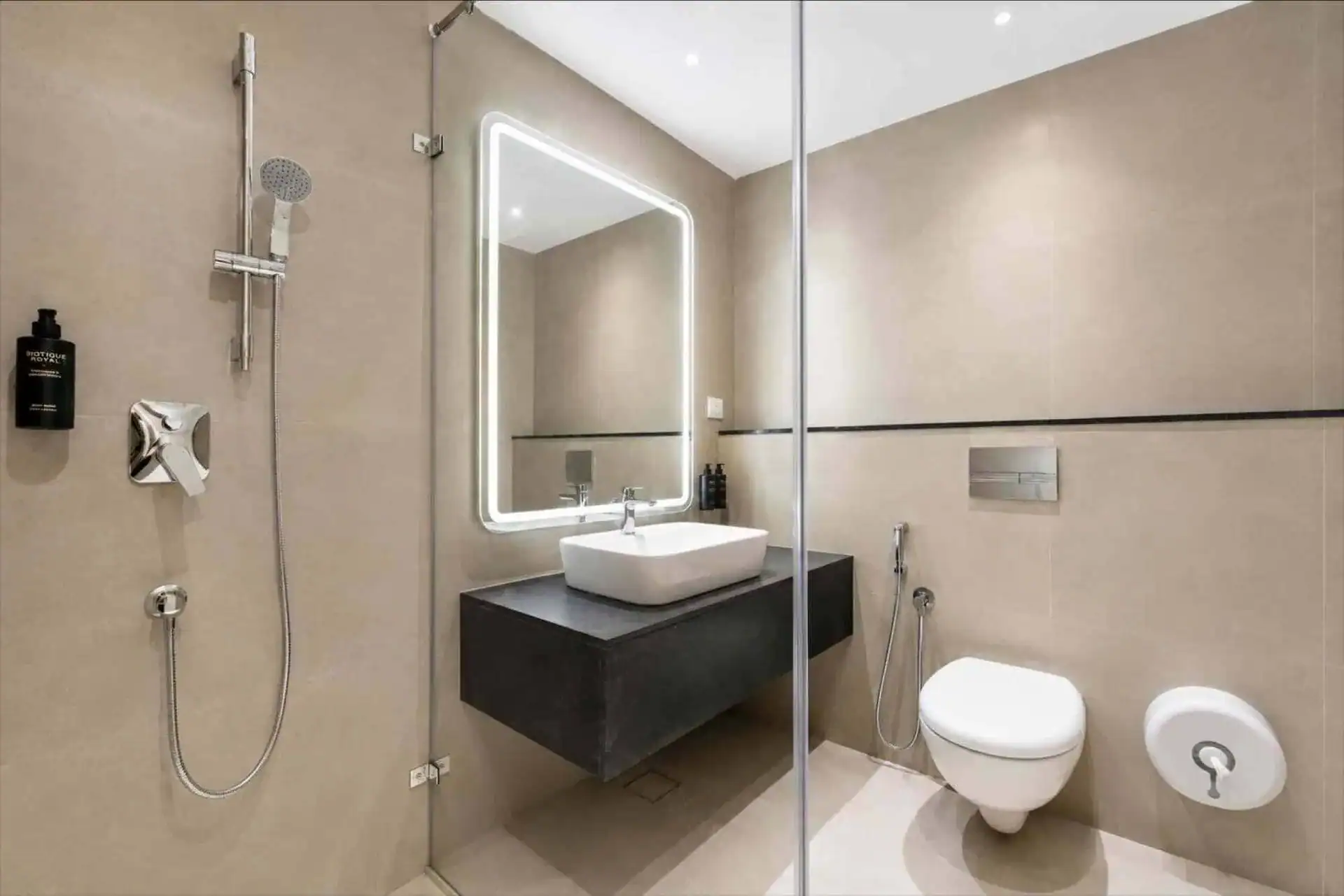 Contemporary en-suite with glass shower, vessel sink, and backlit LED mirror