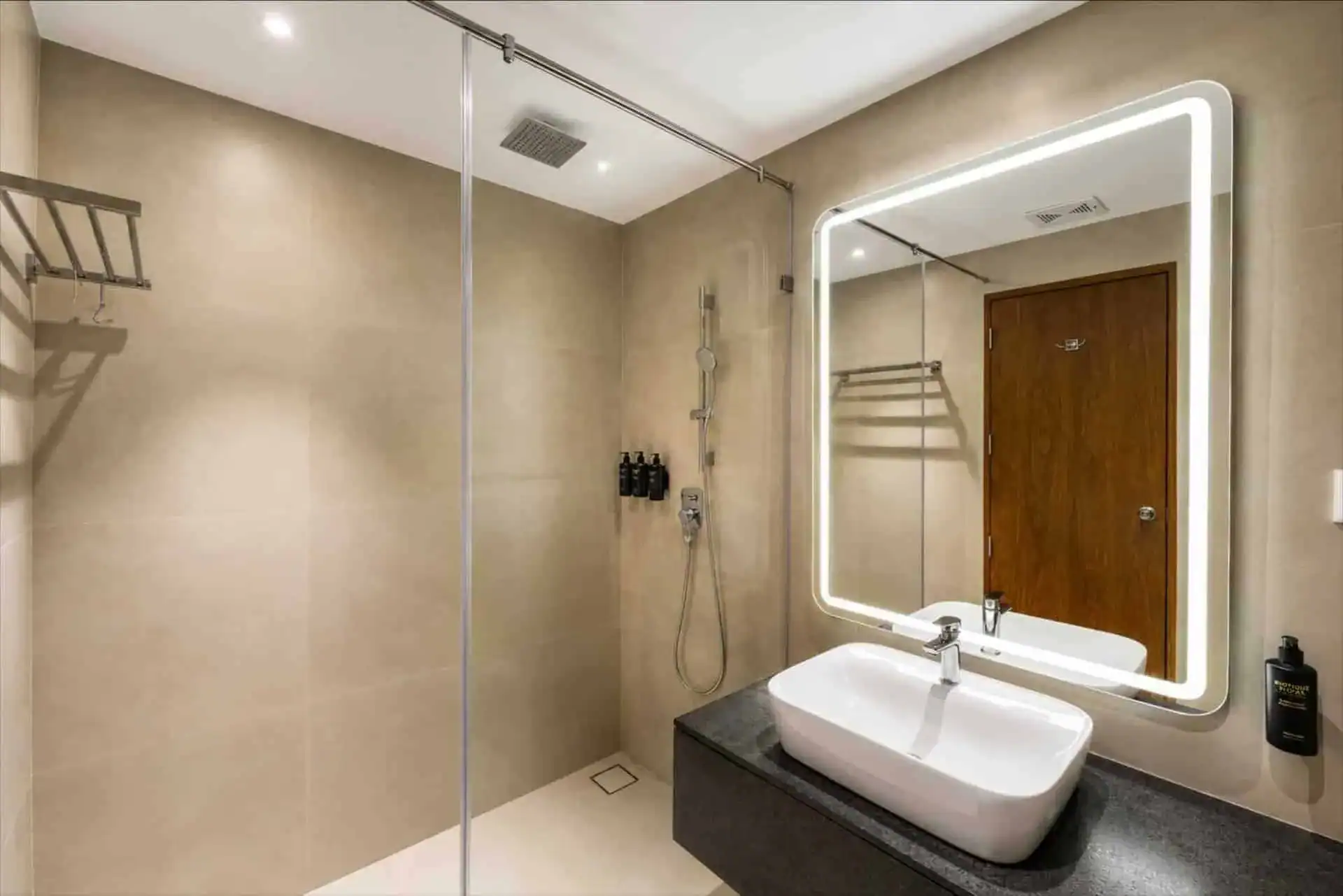Walk-in shower with dark vanity and beige tile en-suite bathroom